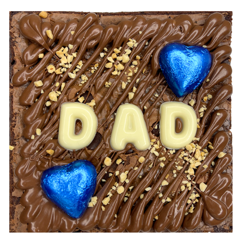 Chocolate Brownie with 'DAD' spelled out using white chocolate letters and blue heart-shaped candies.